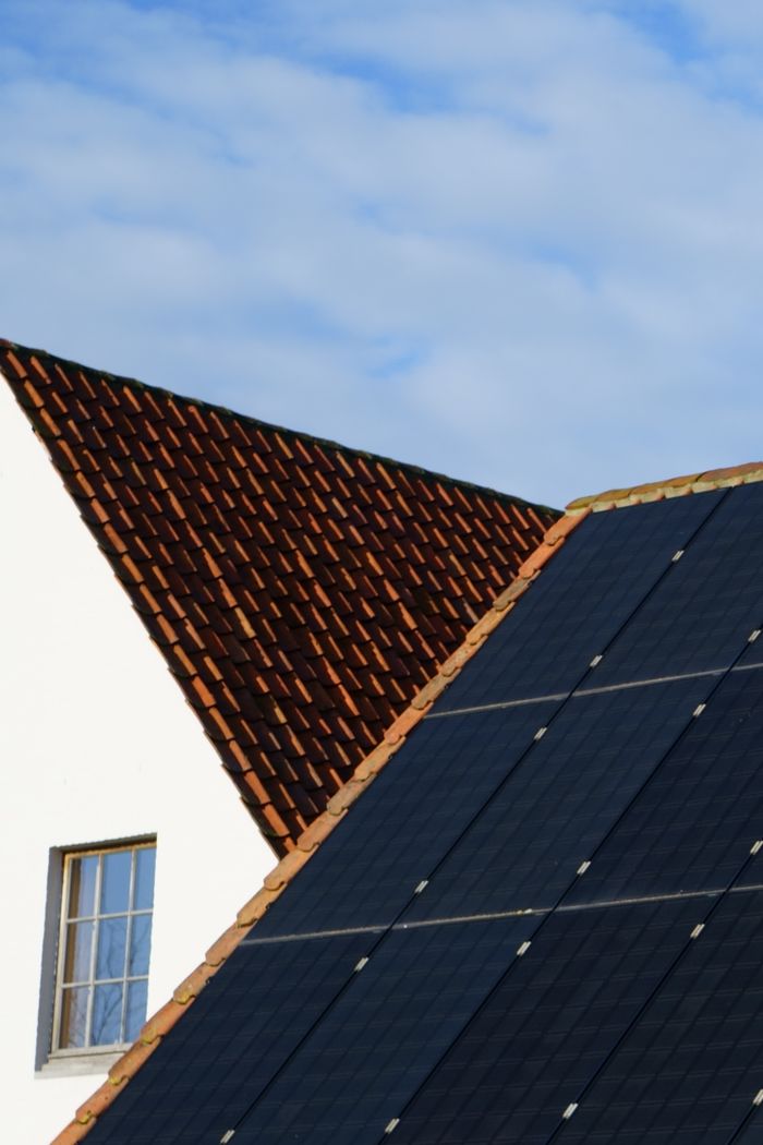 service-02 Close-up of solar panels and a tiled roof, showcasing renewable energy solutions in architecture.