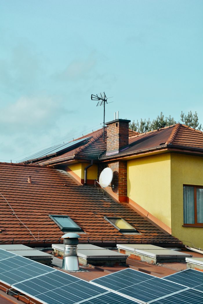 service-02 Yellow building with solar panels and antennas on rooftop in Poland. Eco-friendly technology.