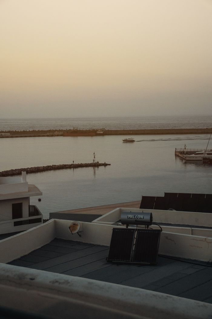 service-06 Serene coastal scene at sunset featuring a rooftop solar panel and tranquil waters.
